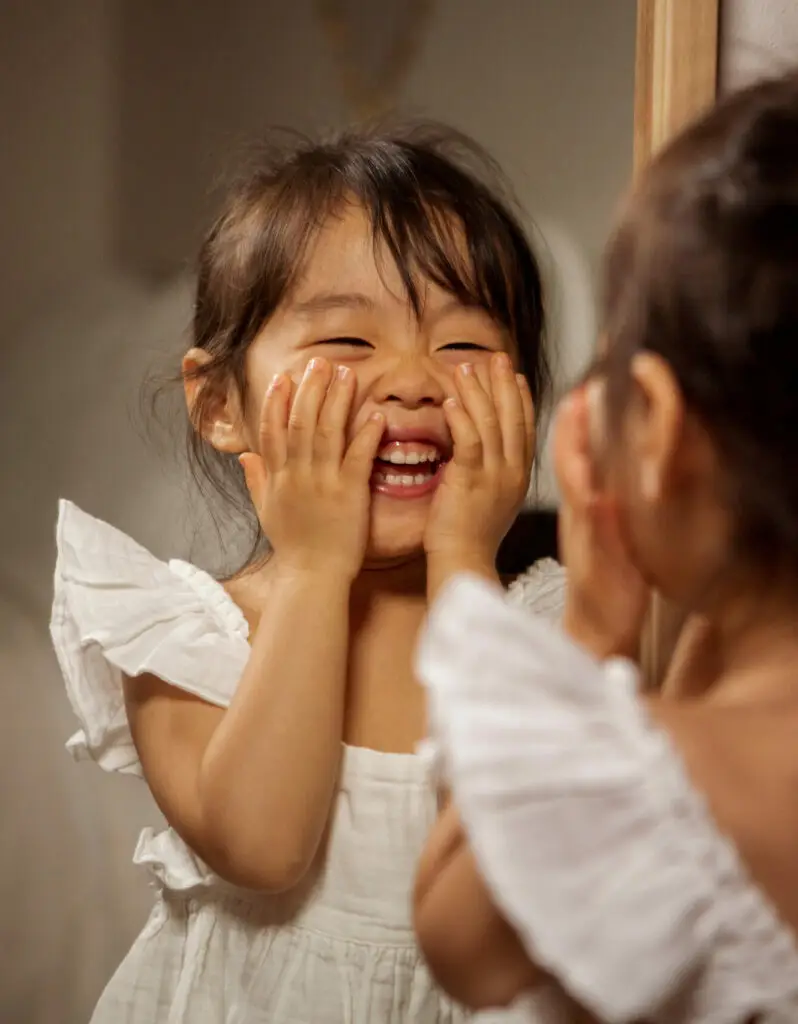 Petite fille qui sourit dans un miroir